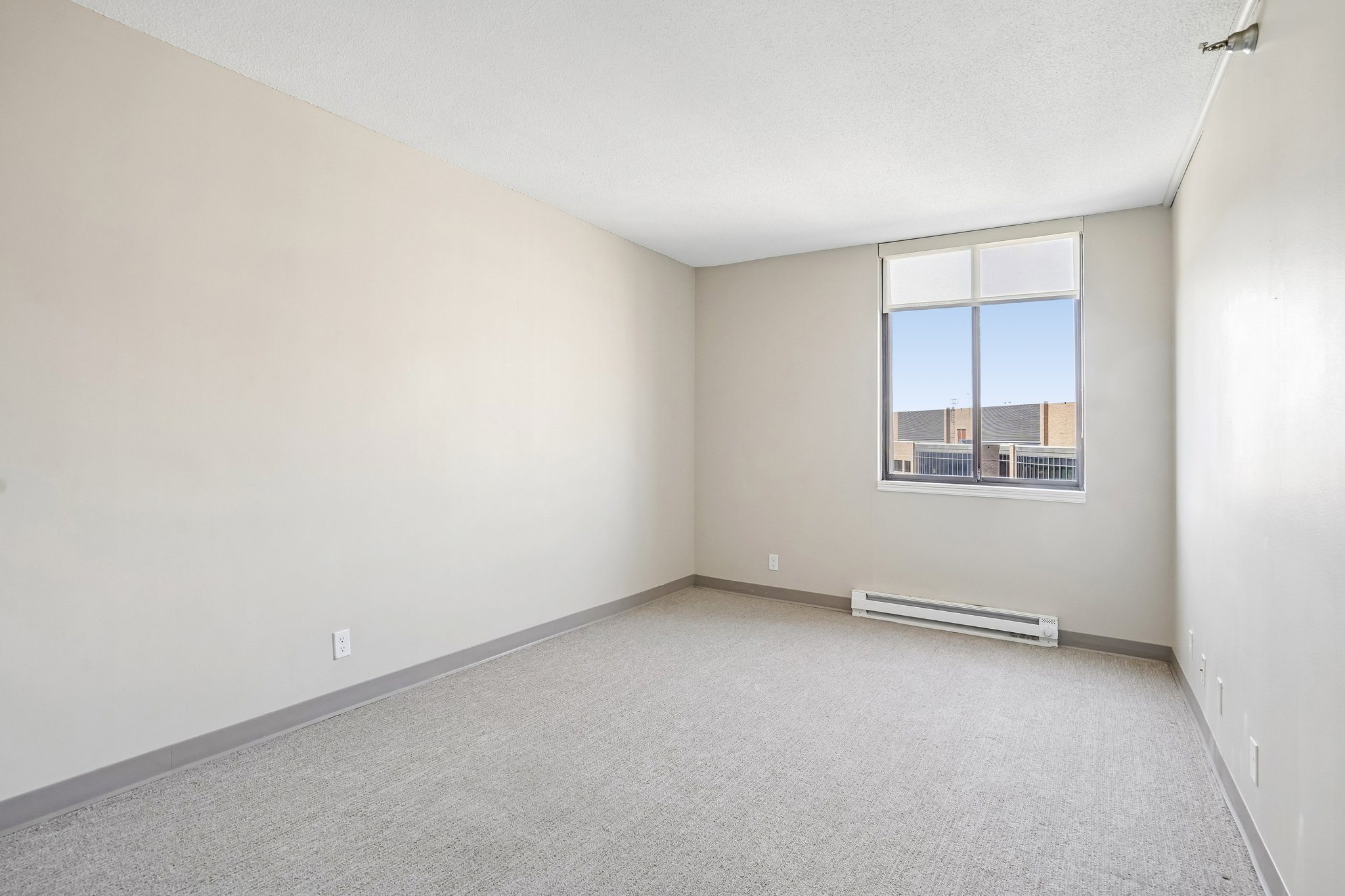 Irvine Park Towers apartment bedroom with carpeted flooring, neutral walls and large window